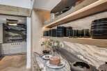 Experience luxury in this stunning kitchen, featuring a dramatic marble backsplash and sleek, modern cabinetry.