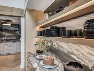 Experience luxury in this stunning kitchen, featuring a dramatic marble backsplash and sleek, modern cabinetry.