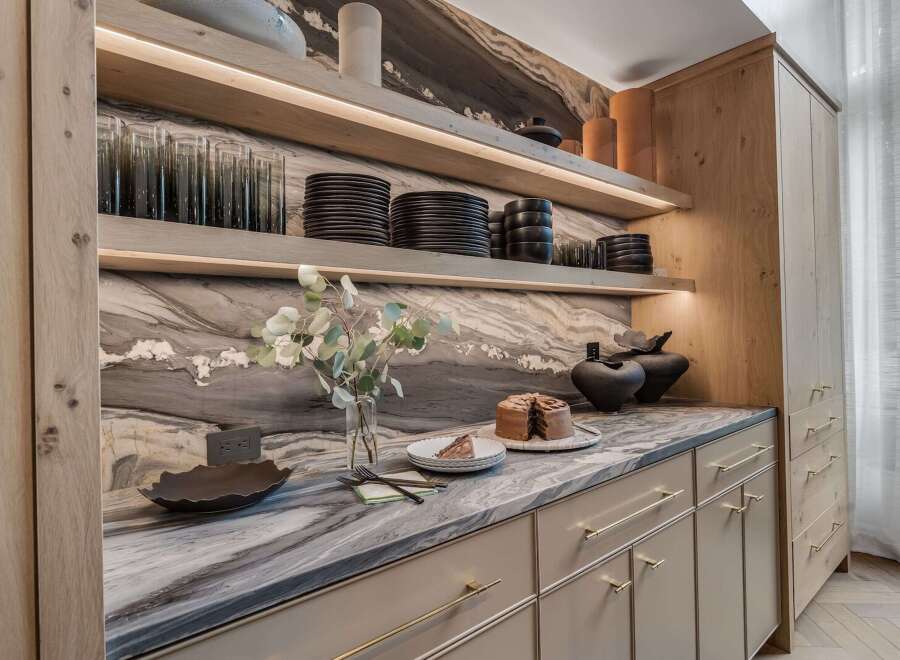 Experience modern luxury in this stunning kitchen featuring sleek, light wood cabinetry and a dramatic marble backsplash.