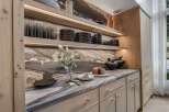 Experience modern luxury in this stunning kitchen featuring sleek, light wood cabinetry and a dramatic marble backsplash.