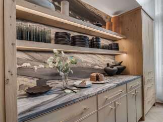 Experience modern luxury in this stunning kitchen featuring sleek, light wood cabinetry and a dramatic marble backsplash.
