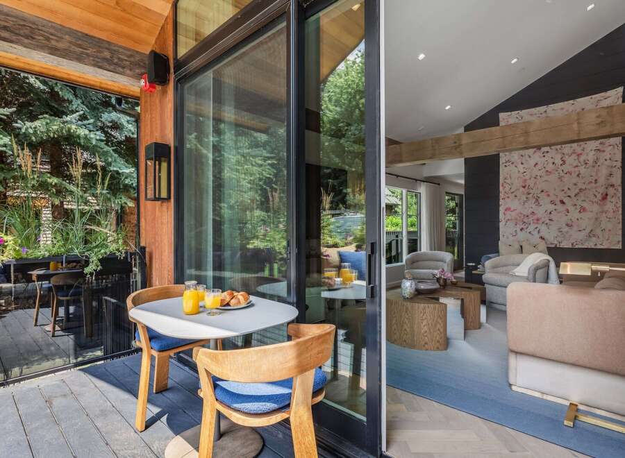 Enjoy your morning coffee on this charming patio, complete with a quaint table and chairs set amidst lush greenery.