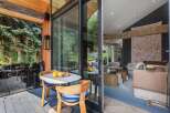Enjoy your morning coffee on this charming patio, complete with a quaint table and chairs set amidst lush greenery.