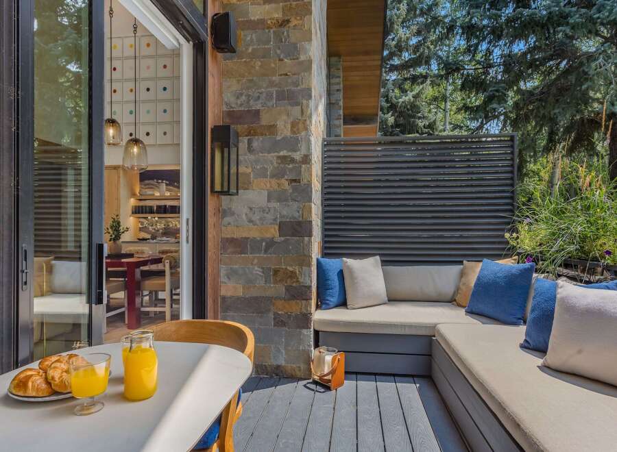 Enjoy your morning coffee and croissants on this charming patio, complete with a built-in seating area and lush greenery.
