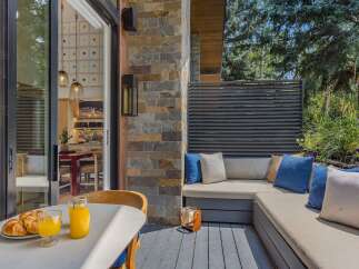 Enjoy your morning coffee and croissants on this charming patio, complete with a built-in seating area and lush greenery.