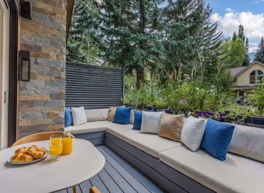 Enjoy your morning coffee on this charming outdoor patio, complete with a built-in sectional sofa and plush cushions.