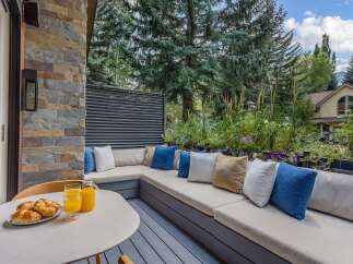 Enjoy your morning coffee on this charming outdoor patio, complete with a built-in sectional sofa and plush cushions.