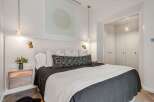 Experience modern luxury in this beautifully appointed bedroom, featuring a plush king-sized bed adorned with elegant linens and decorative pillows.