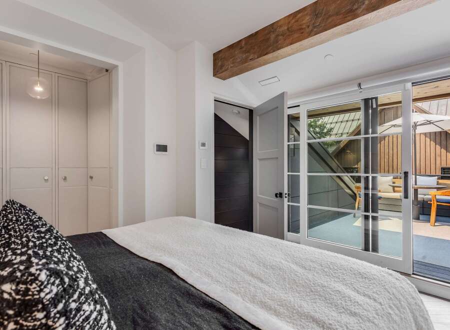 Experience modern luxury in this stunning bedroom featuring a plush bed with a textured throw and a striking black and white accent pillow.