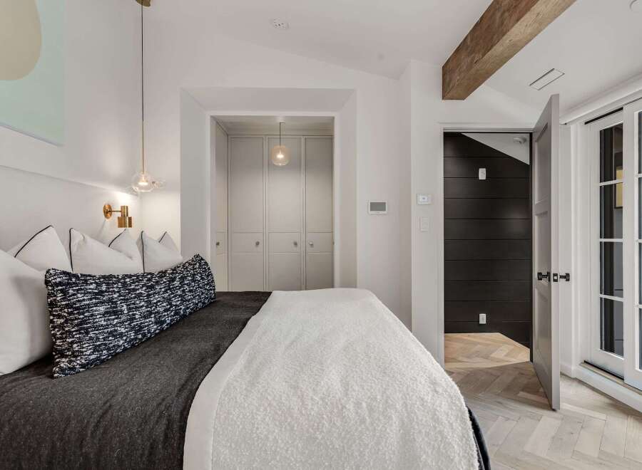 Experience modern comfort in this beautifully appointed bedroom, featuring a plush bed adorned with elegant pillows and a textured throw.