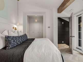 Experience modern comfort in this beautifully appointed bedroom, featuring a plush bed adorned with elegant pillows and a textured throw.