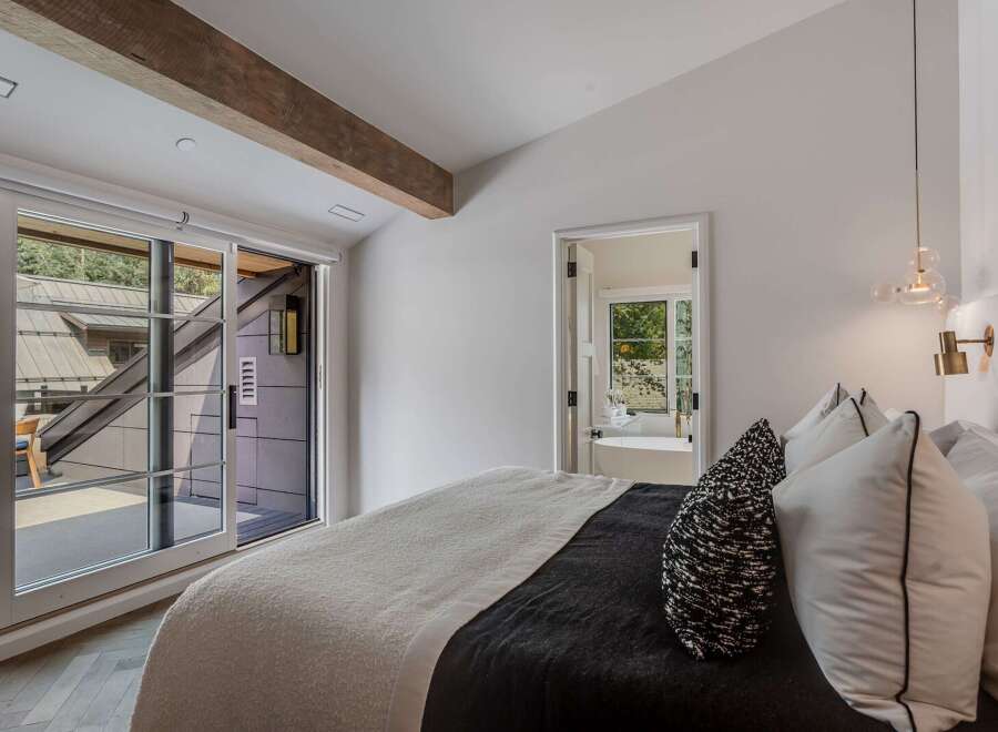 Experience modern luxury in this stunning bedroom featuring a plush bed with a textured throw and elegant accent pillows.