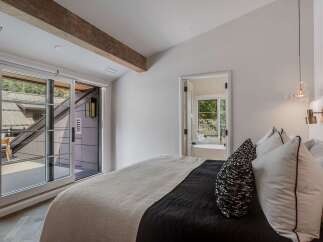Experience modern luxury in this stunning bedroom featuring a plush bed with a textured throw and elegant accent pillows.