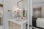 Experience modern luxury in this stunning bathroom featuring a sleek marble vanity with warm wood cabinetry and elegant brass fixtures.