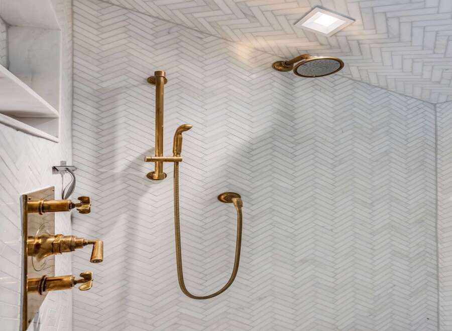 Experience luxury in this modern bathroom featuring a stunning herringbone tile shower.