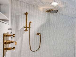Experience luxury in this modern bathroom featuring a stunning herringbone tile shower.
