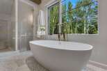 Indulge in luxury with this stunning bathroom featuring a freestanding soaking tub and a separate glass-enclosed shower.