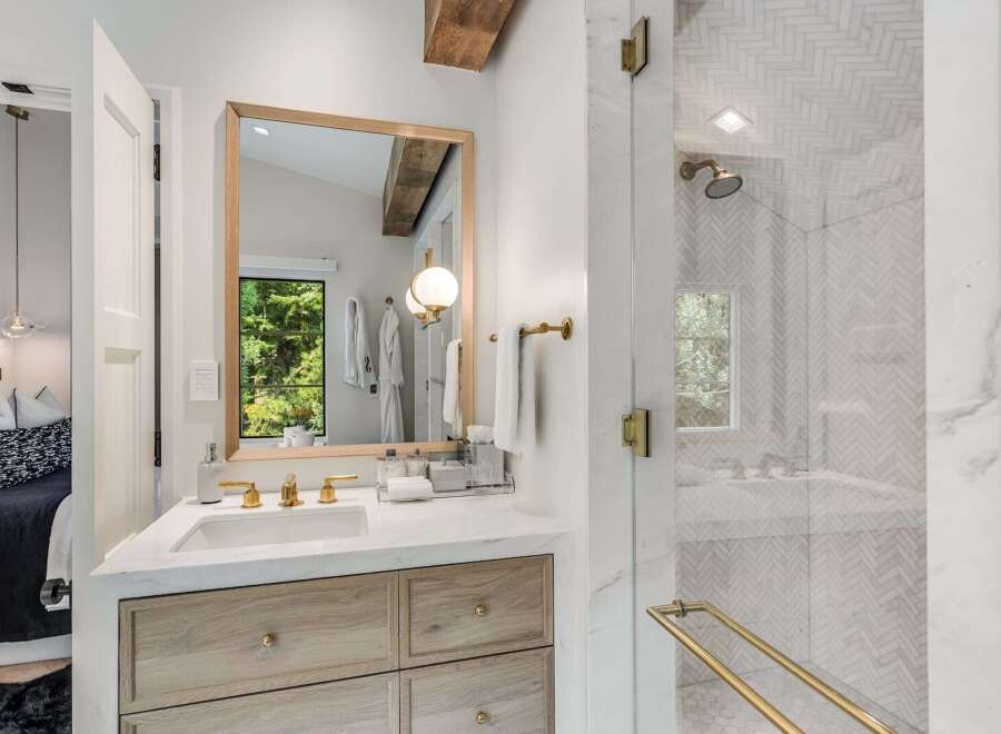 Experience modern luxury in this stunning bathroom, featuring a sleek vanity with marble countertops and warm wood cabinetry.