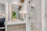 Experience modern luxury in this stunning bathroom, featuring a sleek vanity with marble countertops and warm wood cabinetry.