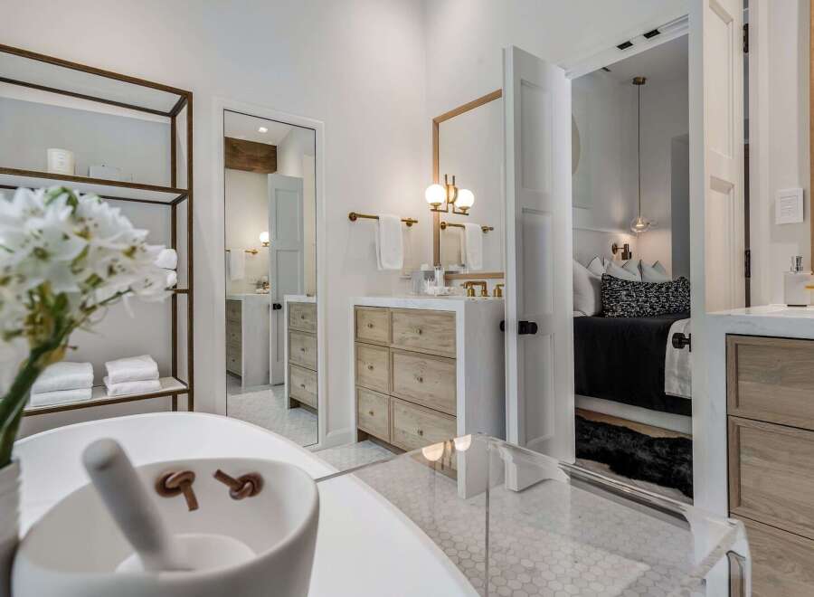 Experience luxury in this stunning bathroom featuring a freestanding tub and a sleek vanity with ample storage.