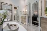 Experience luxury in this stunning bathroom featuring a freestanding tub and a sleek vanity with ample storage.