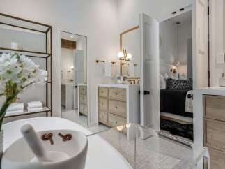 Experience luxury in this stunning bathroom featuring a freestanding tub and a sleek vanity with ample storage.