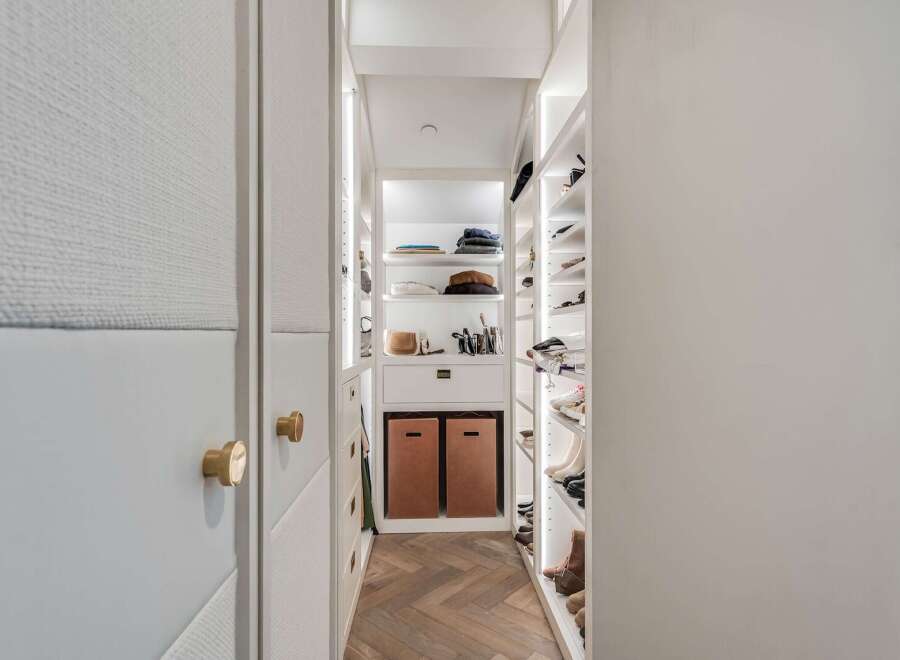 Step into this meticulously organized walk-in closet, featuring custom shelving and ample storage for all your fashion needs.