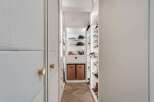 Step into this meticulously organized walk-in closet, featuring custom shelving and ample storage for all your fashion needs.