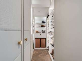 Step into this meticulously organized walk-in closet, featuring custom shelving and ample storage for all your fashion needs.