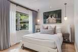 Experience serene comfort in this beautifully appointed bedroom, featuring a plush, textured bed as the centerpiece.