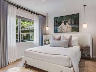 Experience serene comfort in this beautifully appointed bedroom, featuring a plush, textured bed as the centerpiece.