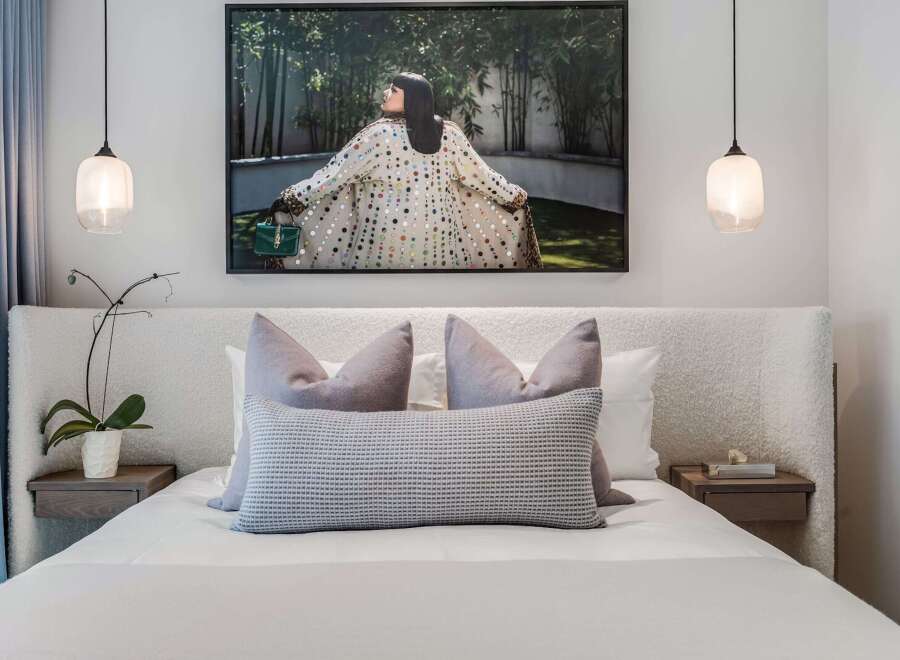 Experience luxurious comfort in this master bedroom, featuring a plush, textured headboard and a king-sized bed adorned with elegant throw pillows.