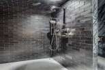 Experience modern luxury in this stunning shower featuring sleek, dark subway tiles that create a sophisticated ambiance.