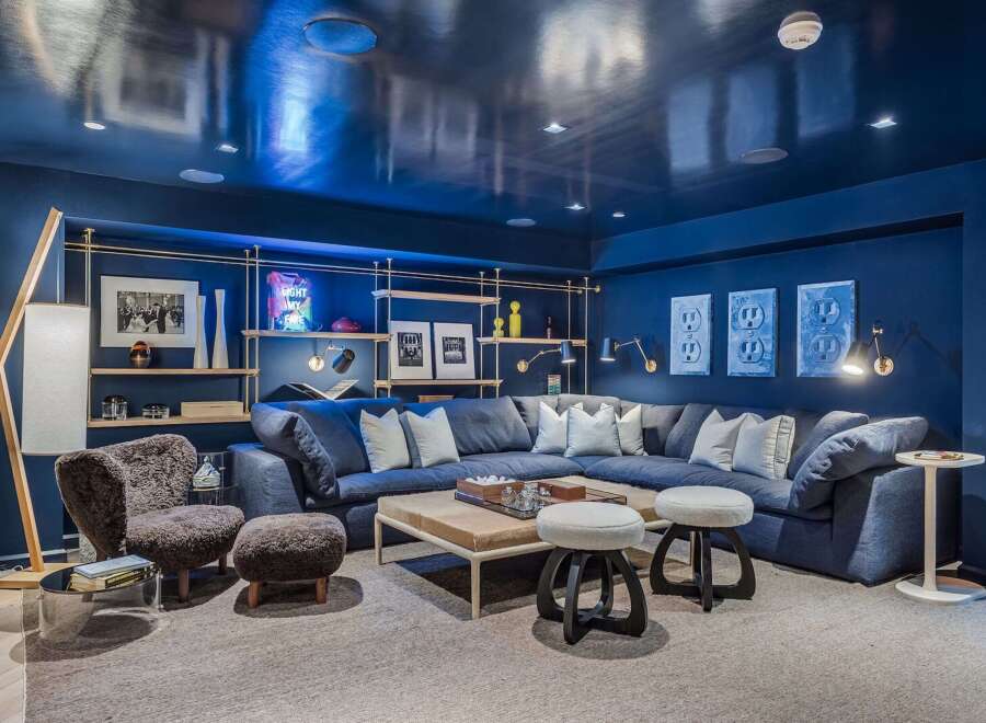 Experience ultimate relaxation in this luxurious media room, featuring a deep navy palette and a plush sectional sofa perfect for movie nights.