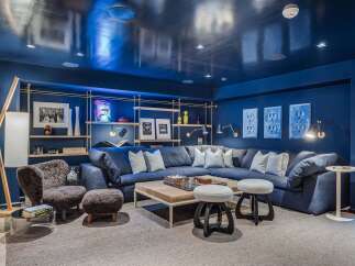 Experience ultimate relaxation in this luxurious media room, featuring a deep navy palette and a plush sectional sofa perfect for movie nights.