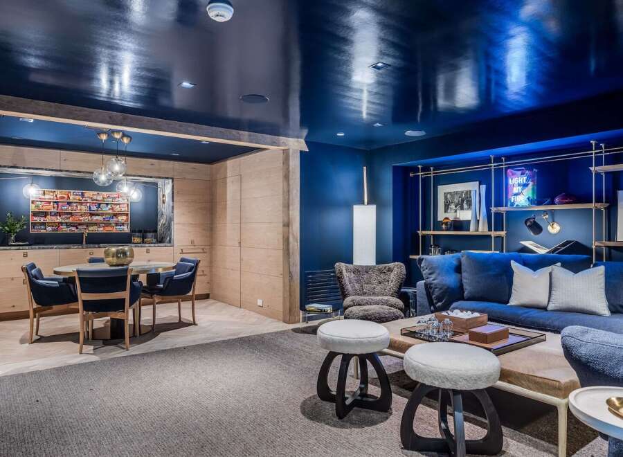 Step into a stylish entertainment space featuring a sleek, high-gloss navy ceiling that adds a dramatic flair.