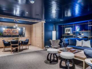 Step into a stylish entertainment space featuring a sleek, high-gloss navy ceiling that adds a dramatic flair.