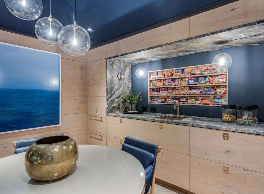 Experience a unique and stylish kitchen area featuring a stunning display of candy on open shelving, perfect for a fun and inviting atmosphere.