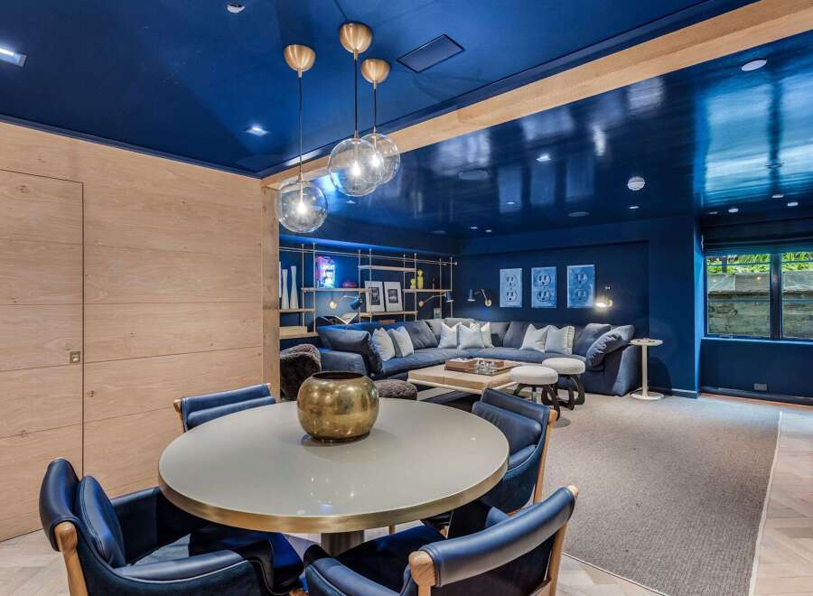 Experience luxurious living in this stunning entertainment space, featuring a deep navy blue ceiling and walls that create a dramatic and sophisticated ambiance.