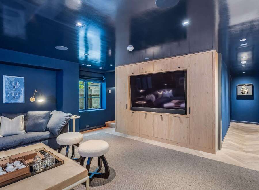 Experience luxury and comfort in this stunning media room, featuring a sleek, high-gloss navy ceiling that creates a dramatic and sophisticated ambiance.