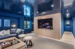 Experience luxury and comfort in this stunning media room, featuring a sleek, high-gloss navy ceiling that creates a dramatic and sophisticated ambiance.
