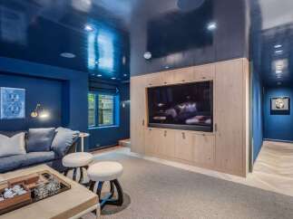 Experience luxury and comfort in this stunning media room, featuring a sleek, high-gloss navy ceiling that creates a dramatic and sophisticated ambiance.