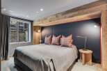Experience ultimate comfort in this luxurious bedroom, featuring a plush king-size bed adorned with stylish plaid pillows.