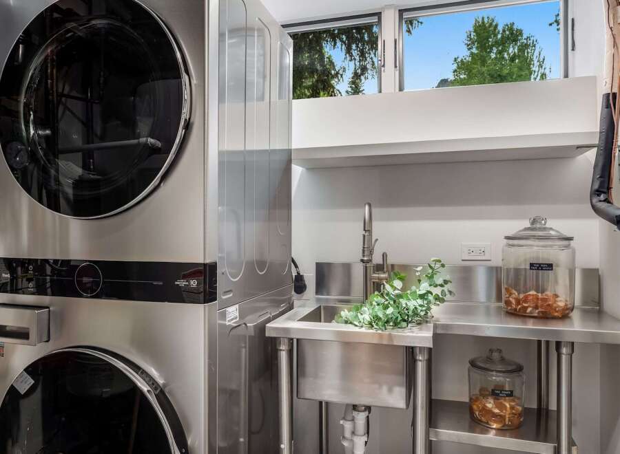 This modern laundry room features a stacked LG washer and dryer set, offering space-saving efficiency.