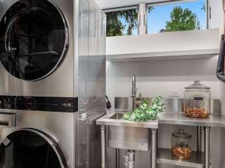 This modern laundry room features a stacked LG washer and dryer set, offering space-saving efficiency.