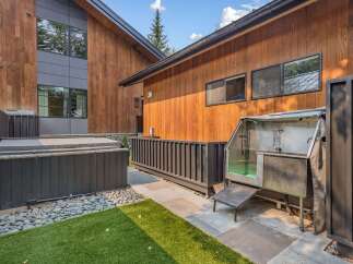 Experience outdoor luxury with this property's modern amenities, including a covered hot tub perfect for relaxation and a professional-grade outdoor dog grooming station.
