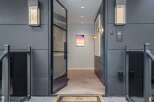 Step into a modern entryway featuring a sleek glass door and contemporary exterior lighting.