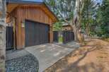 Discover modern living with this stunning property featuring a sleek wooden exterior and a striking black garage door.