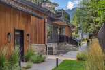 Experience modern luxury in this stunning home featuring a striking combination of warm wood siding and sleek dark metal accents.