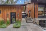 Experience modern luxury in this stunning home featuring warm wood siding and natural stone accents.